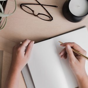 Image of woman drawing graphic design elements on a notebook.